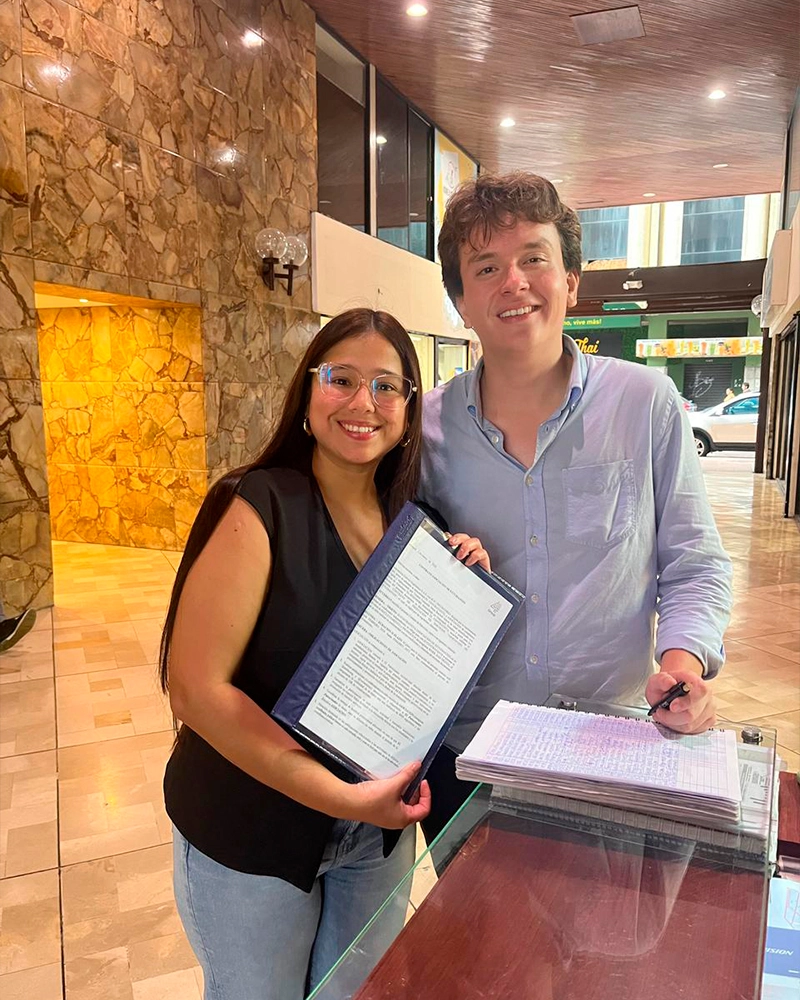 Representantes mostrando documentos de convenio internacional con Forever Experience